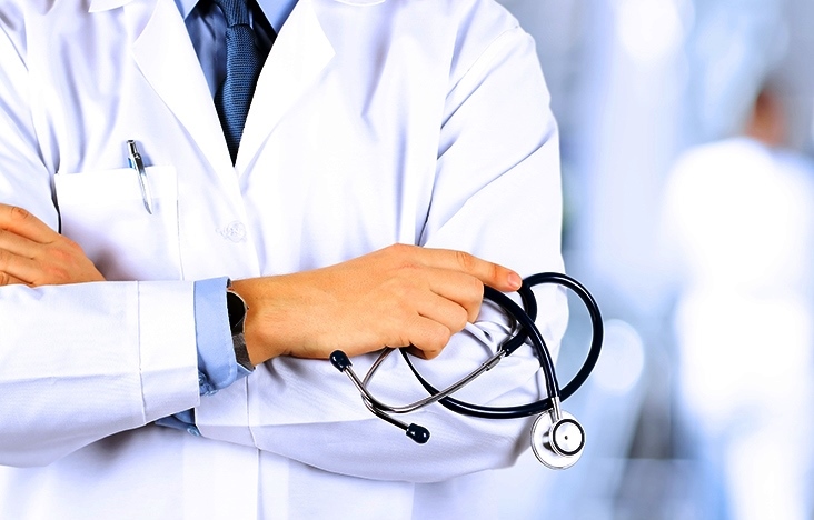 Portrait an unknown male doctor holding a stethoscope behind